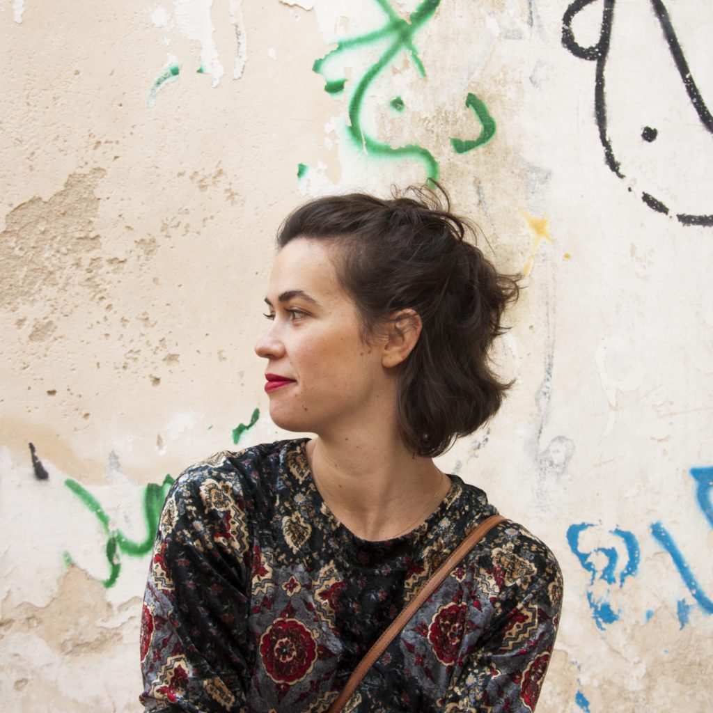 Izabela Soldaty u profilu ispred zida s grafitima, Beč